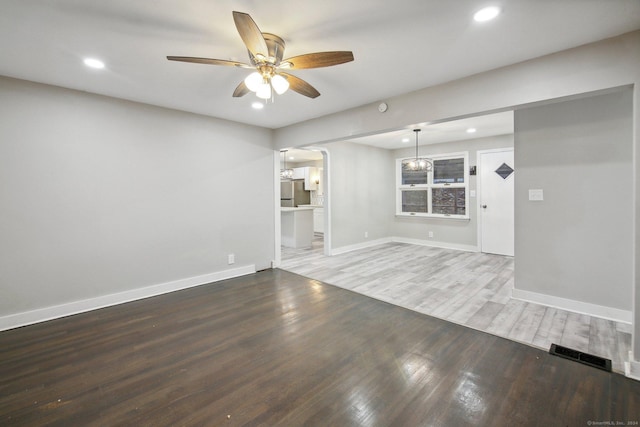 empty room featuring hardwood / wood-style floors and ceiling fan with notable chandelier