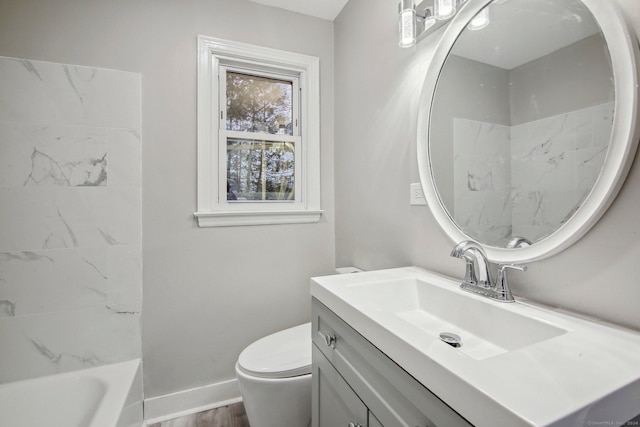 full bathroom with tiled shower / bath, vanity, wood-type flooring, and toilet