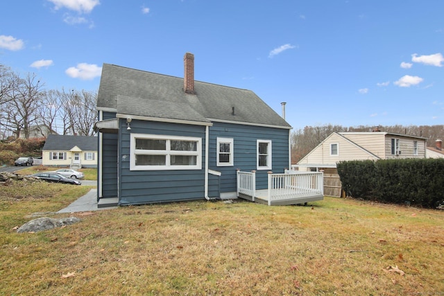 back of property featuring a lawn and a deck