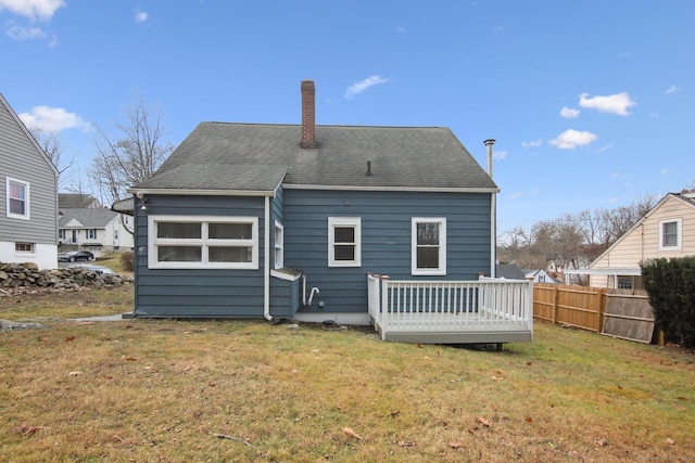 back of house with a deck and a lawn