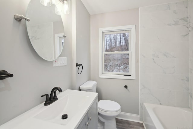 full bathroom with hardwood / wood-style floors, vanity, toilet, and tiled shower / bath combo