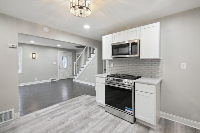 kitchen featuring white cabinets, appliances with stainless steel finishes, and light wood-type flooring