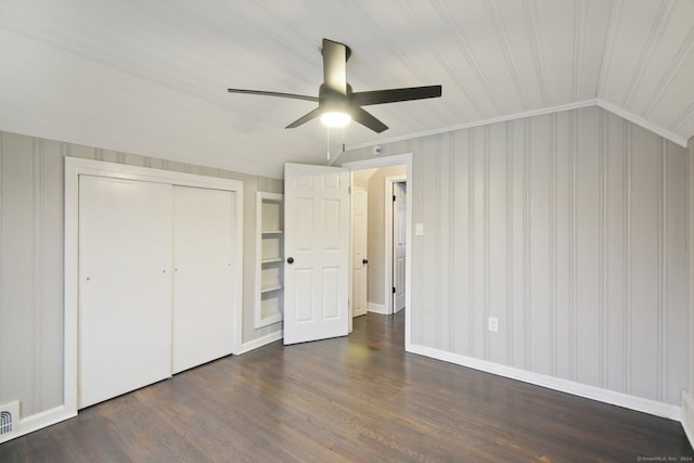 unfurnished bedroom with ceiling fan, dark wood-type flooring, crown molding, a closet, and lofted ceiling