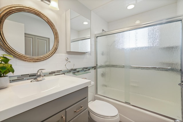 full bathroom featuring tasteful backsplash, enclosed tub / shower combo, toilet, vanity, and tile walls