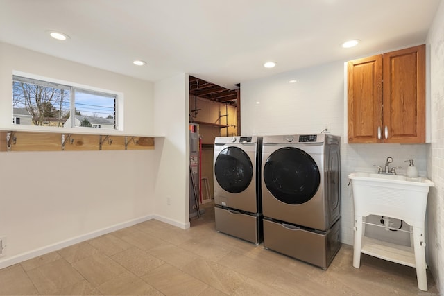 washroom with washer and dryer and cabinets