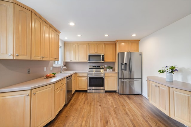 kitchen featuring light brown cabinets, light wood-type flooring, sink, and appliances with stainless steel finishes