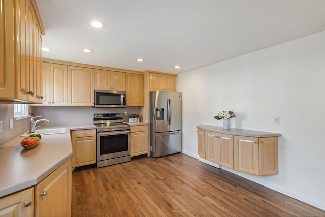 kitchen featuring hardwood / wood-style flooring, light brown cabinets, sink, and appliances with stainless steel finishes