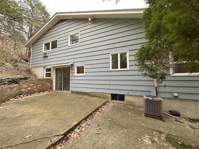 rear view of property with central AC unit and a patio area