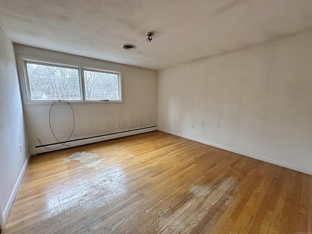 spare room featuring light hardwood / wood-style floors and a baseboard heating unit