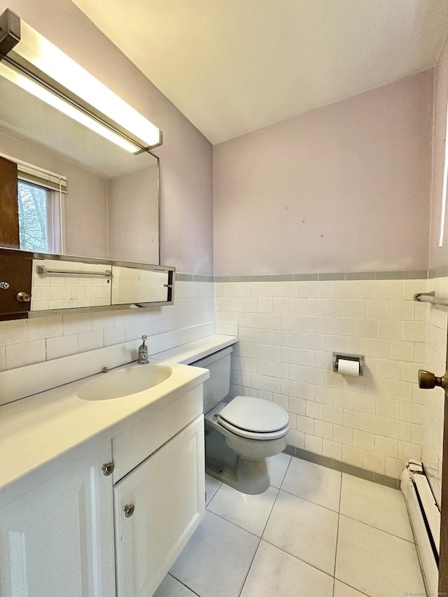 bathroom with tile patterned floors, vanity, a baseboard heating unit, tile walls, and toilet