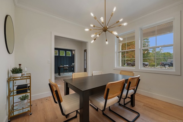 dining space with ornamental molding, light hardwood / wood-style floors, and an inviting chandelier