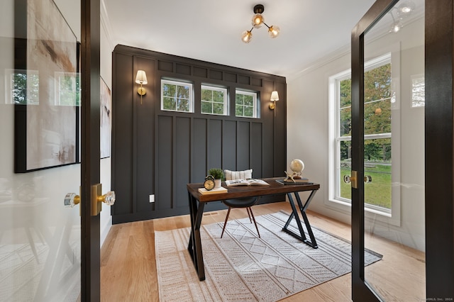 office featuring light hardwood / wood-style floors, ornamental molding, and a wealth of natural light