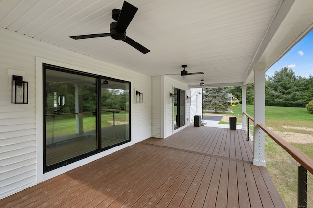 deck featuring ceiling fan and a yard