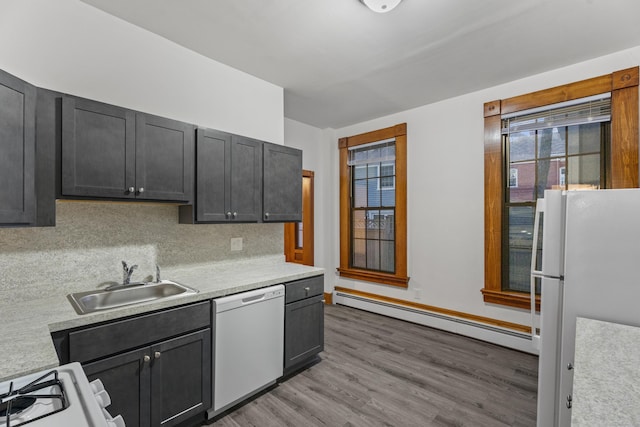 kitchen with white appliances, sink, light hardwood / wood-style flooring, decorative backsplash, and baseboard heating