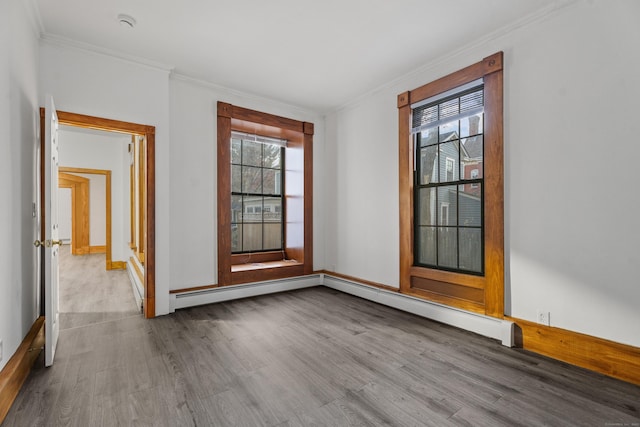 spare room with crown molding, plenty of natural light, a baseboard radiator, and light wood-type flooring