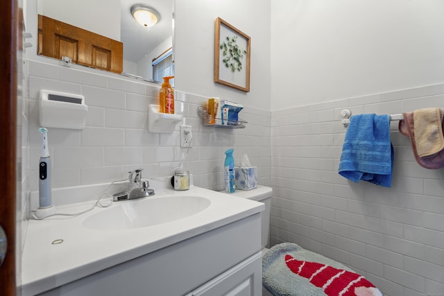 bathroom featuring vanity and tile walls