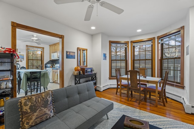 living room featuring ceiling fan, hardwood / wood-style floors, and a baseboard radiator