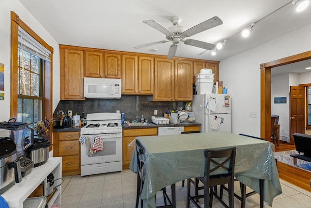 kitchen featuring ceiling fan, light tile patterned flooring, decorative backsplash, and white appliances