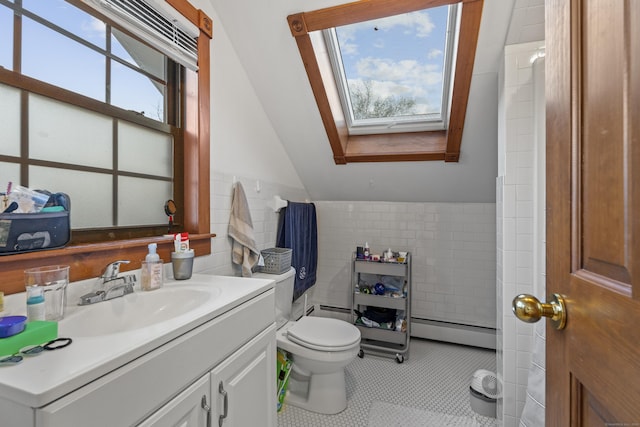 bathroom featuring lofted ceiling with skylight, tile patterned flooring, vanity, and a baseboard heating unit