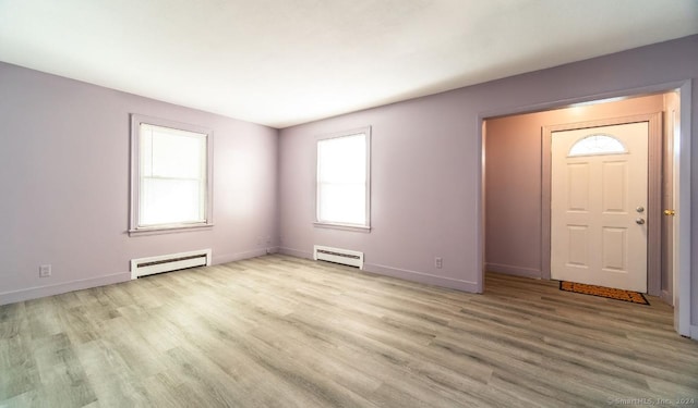 entrance foyer with light hardwood / wood-style floors and a baseboard heating unit