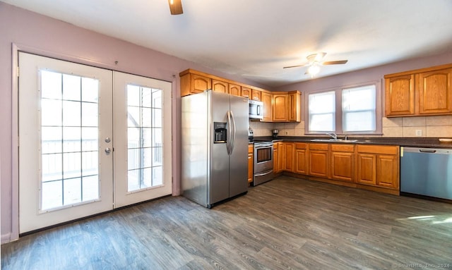 kitchen featuring decorative backsplash, appliances with stainless steel finishes, french doors, ceiling fan, and dark wood-type flooring