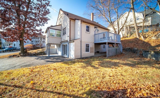 rear view of house featuring a yard and a deck