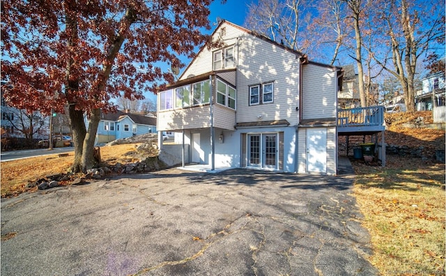 back of property with a sunroom and a wooden deck