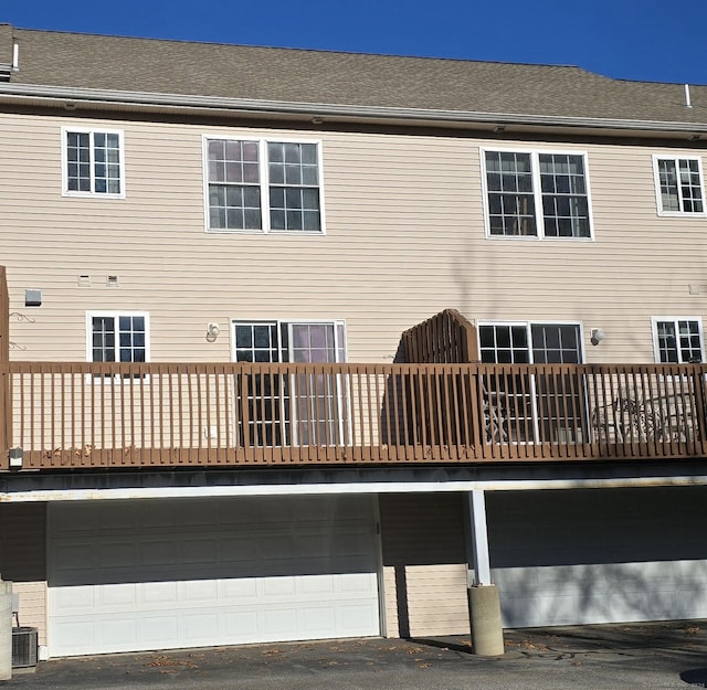 back of house with cooling unit and a garage