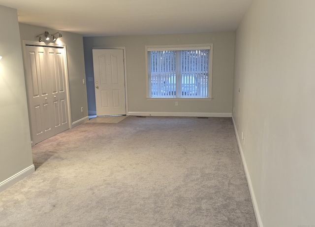 spare room featuring light carpet