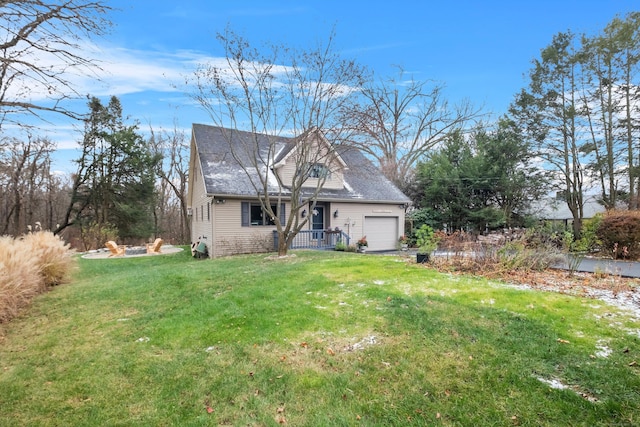 view of front of house with a garage, a front yard, and an outdoor fire pit