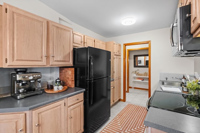 kitchen with sink, light tile patterned floors, black refrigerator, light brown cabinetry, and decorative backsplash