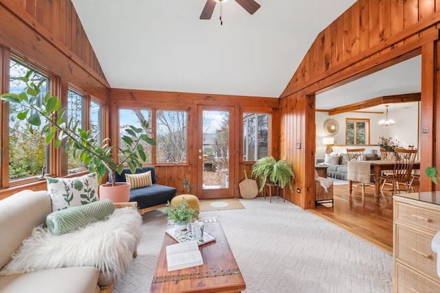 sunroom / solarium with ceiling fan with notable chandelier and lofted ceiling with beams