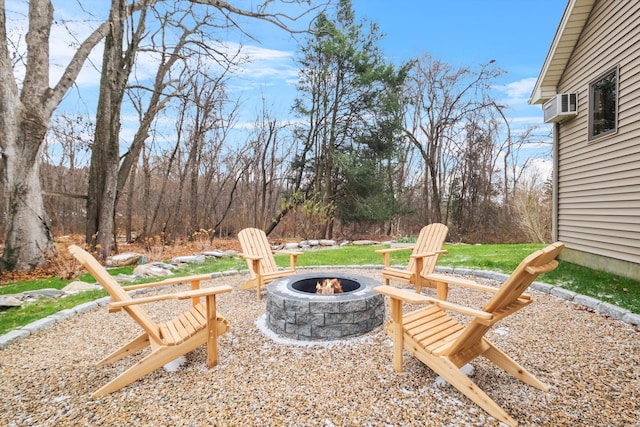 view of patio / terrace featuring an outdoor fire pit and an AC wall unit