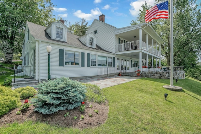 back of house featuring a patio area, a balcony, and a lawn