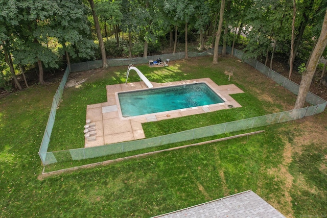 view of swimming pool featuring a lawn, a patio area, and a water slide