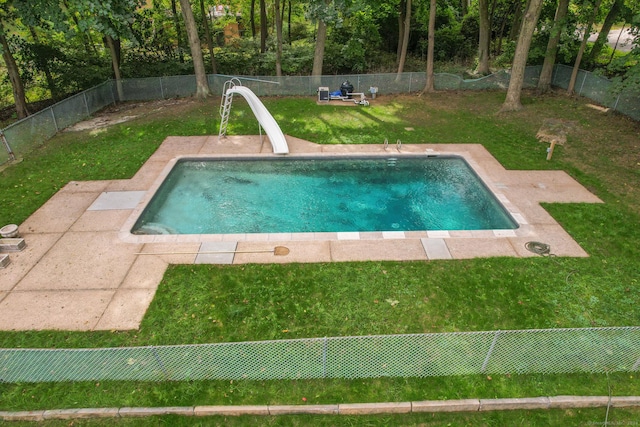 view of swimming pool featuring a lawn and a water slide