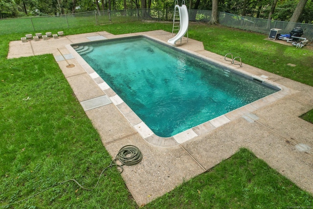 view of swimming pool with a yard and a water slide