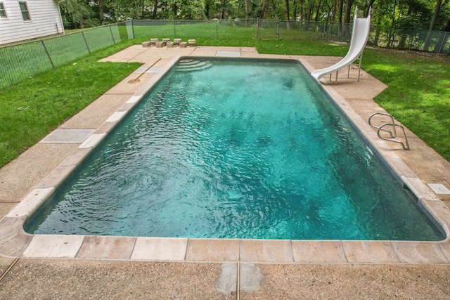 view of swimming pool featuring a lawn and a water slide