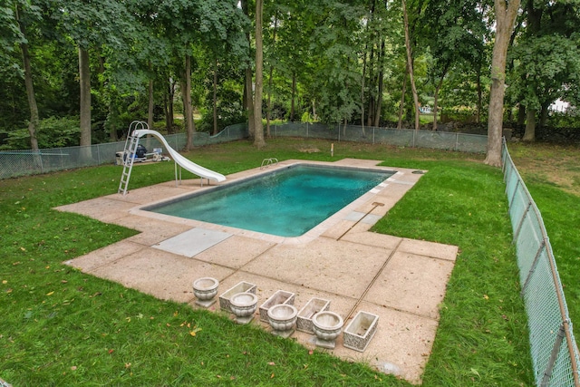 view of swimming pool featuring a yard, a patio, and a water slide