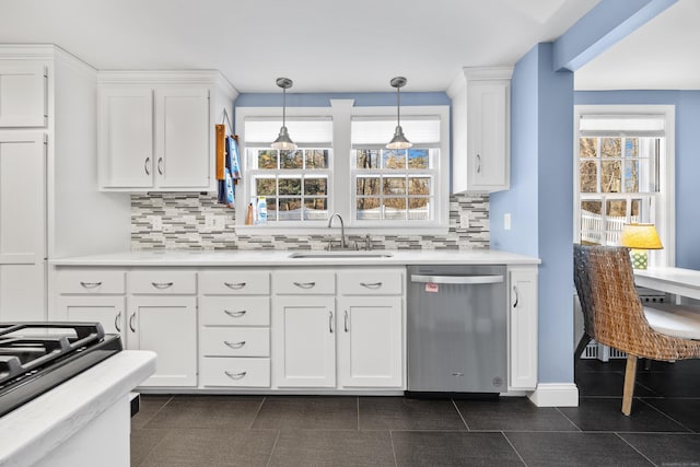 kitchen featuring a wealth of natural light, sink, stainless steel dishwasher, and decorative light fixtures