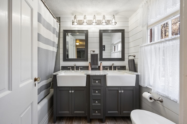 bathroom featuring a shower with curtain, vanity, a textured ceiling, hardwood / wood-style flooring, and toilet