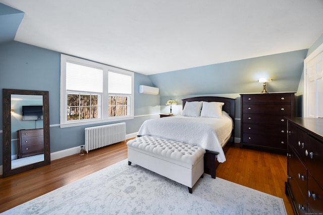 bedroom featuring a wall mounted AC, hardwood / wood-style flooring, radiator, and lofted ceiling