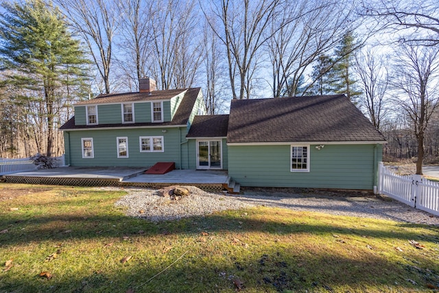 back of property with a lawn and a deck