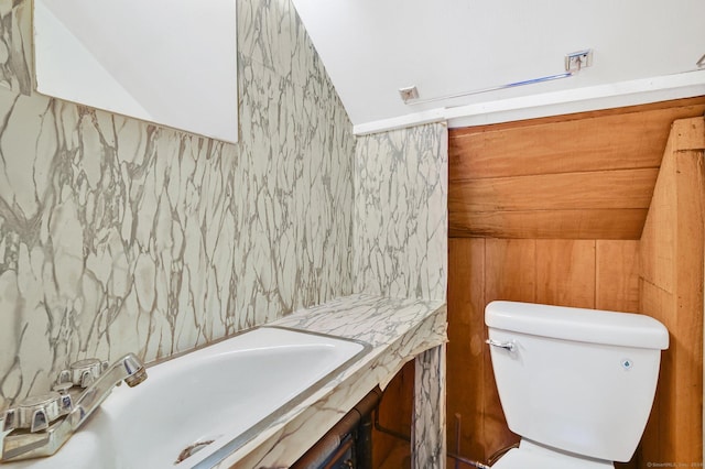 bathroom featuring toilet and lofted ceiling