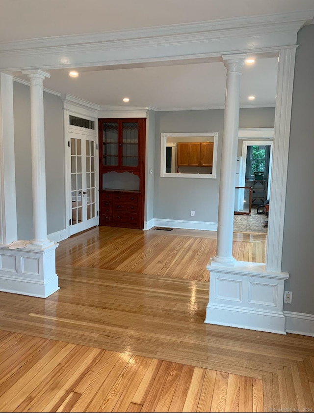 interior space featuring light wood-type flooring, crown molding, and french doors