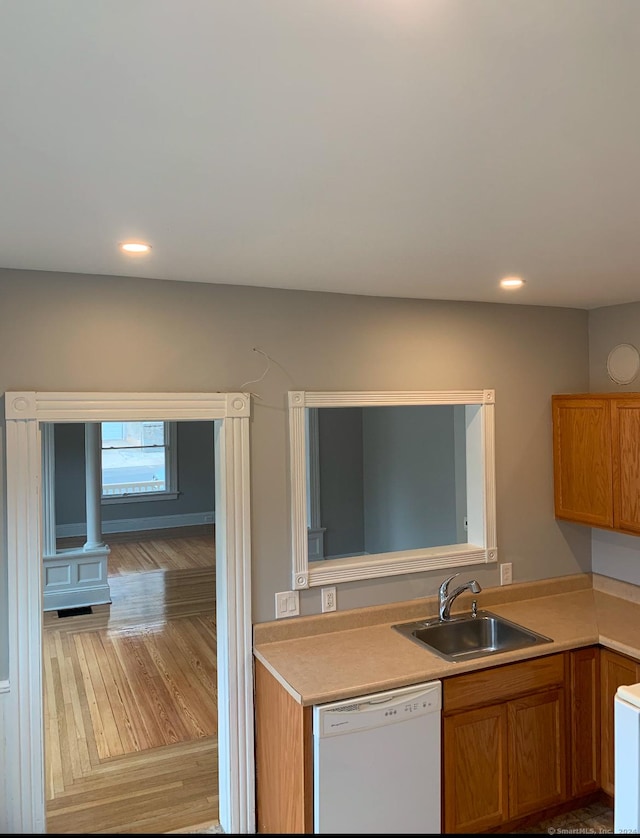 kitchen featuring white dishwasher, light hardwood / wood-style flooring, and sink