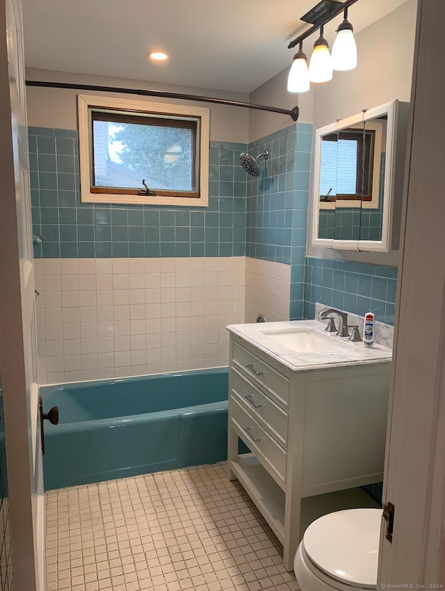 full bathroom featuring tile patterned floors, tiled shower / bath combo, toilet, and vanity