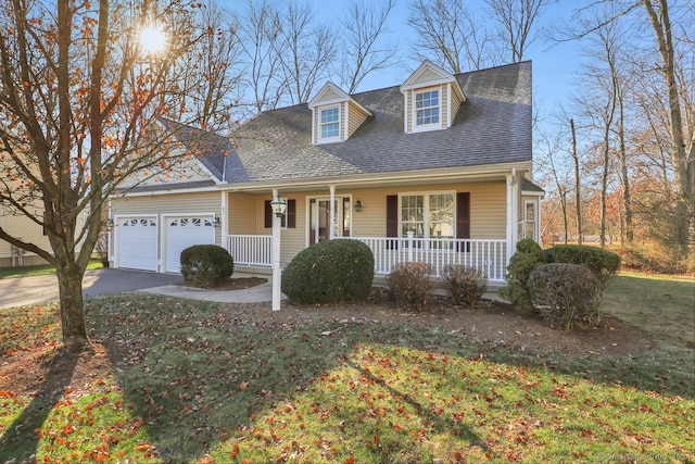 new england style home featuring a front lawn, a porch, and a garage