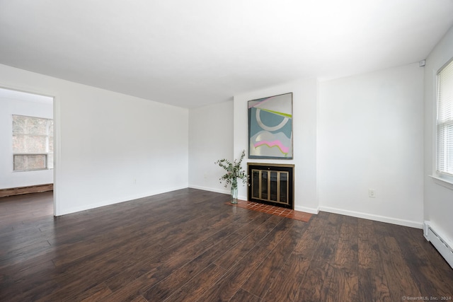 unfurnished living room featuring a baseboard radiator and dark hardwood / wood-style floors