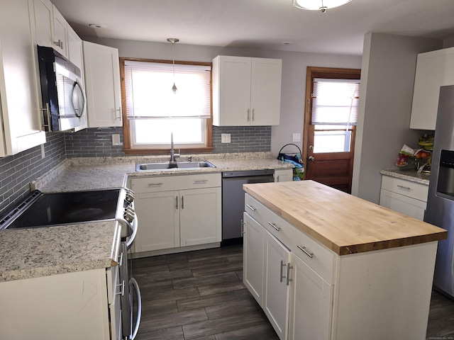 kitchen with sink, white cabinets, stainless steel appliances, and a kitchen island